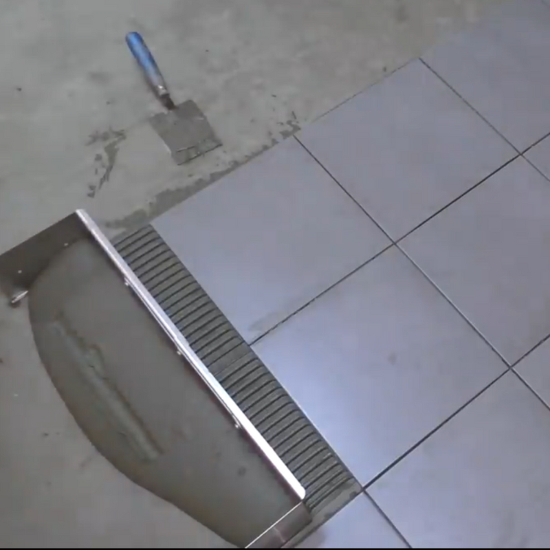 Adjustable notched trowel for fast and equal application of adhesive on the floor